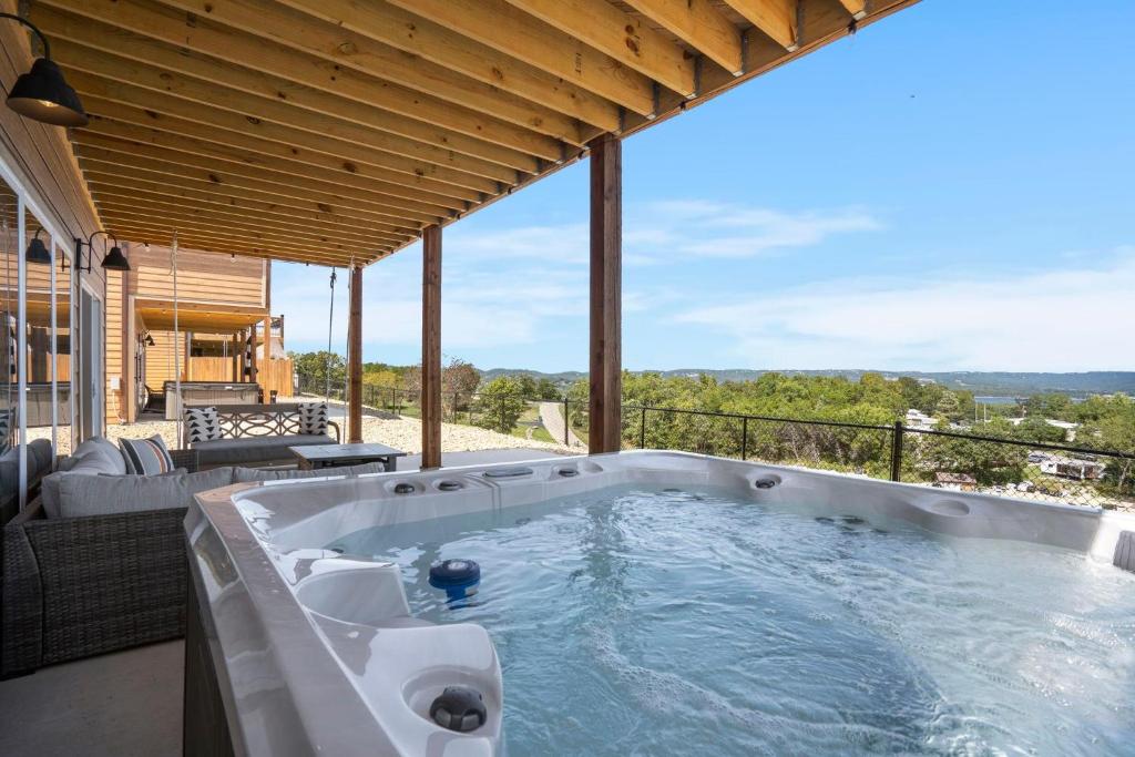 a jacuzzi tub on a patio with a view at Legacy Lakeside Retreat in Kimberling City