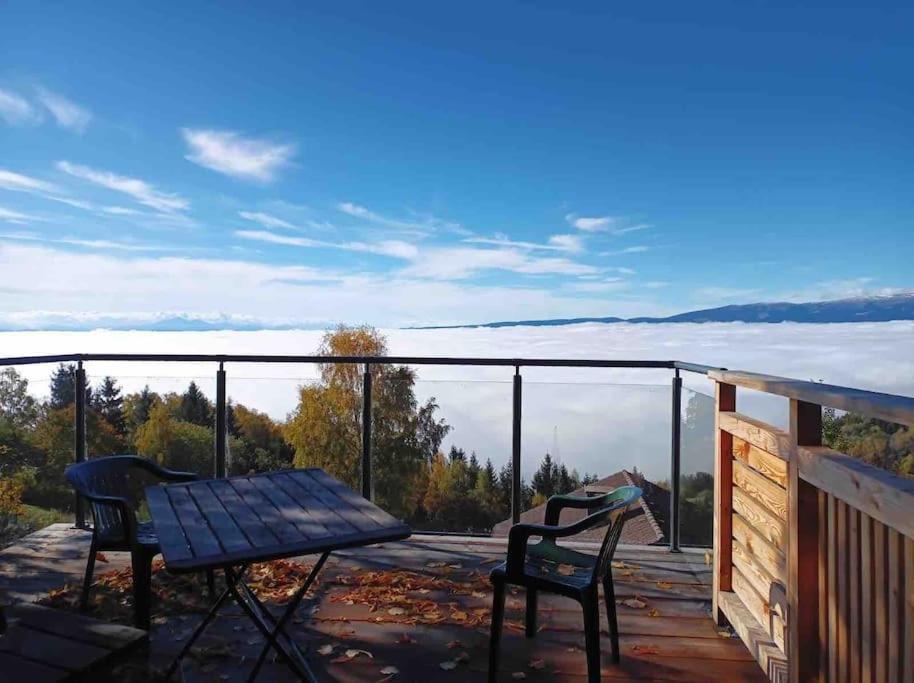 a deck with a table and two chairs and a view at Ferienhaus Almzeit Koralpe in Rieding