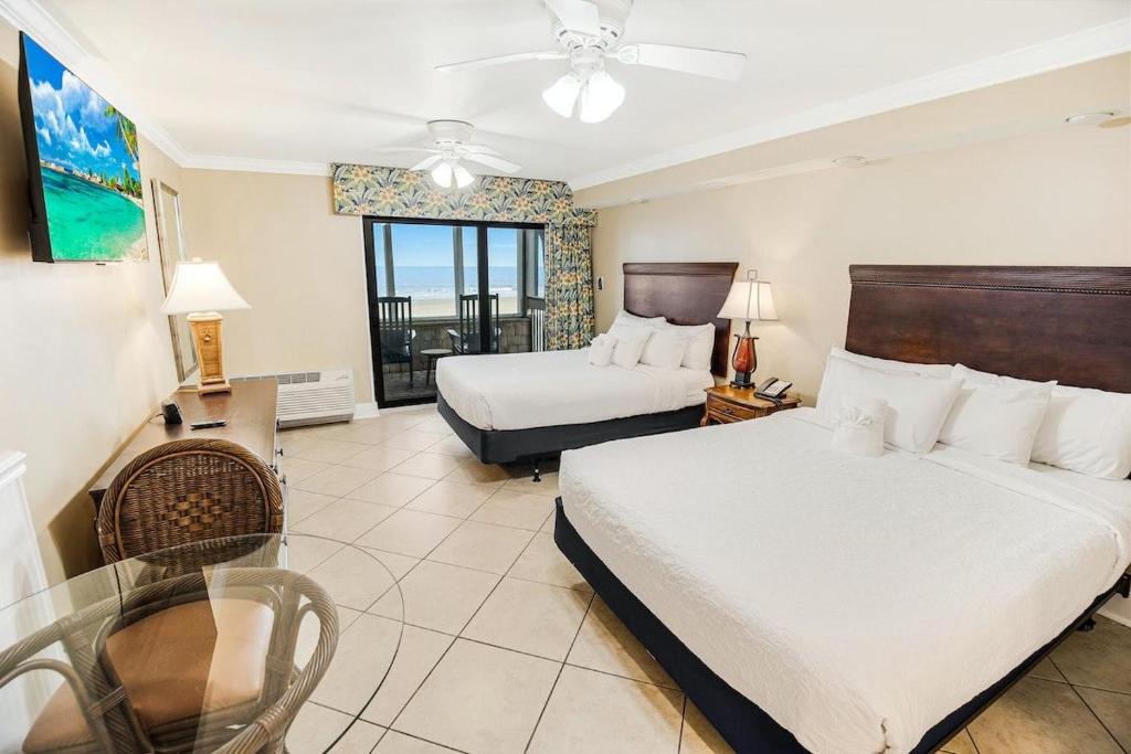 ein Hotelzimmer mit 2 Betten und einem Fenster in der Unterkunft Bright and Beautiful Dunes Room 1st Floor in Pawleys Island