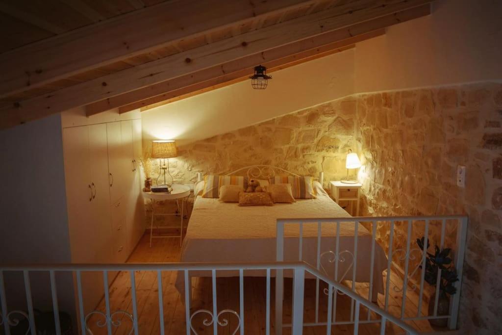 a bedroom with a bed in a stone wall at The Secret Ontas, Traditional stone house in Rethymno