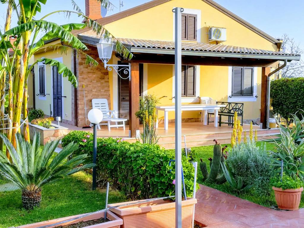 a yellow house with a porch and a patio at Villa Mimmo in Lascari