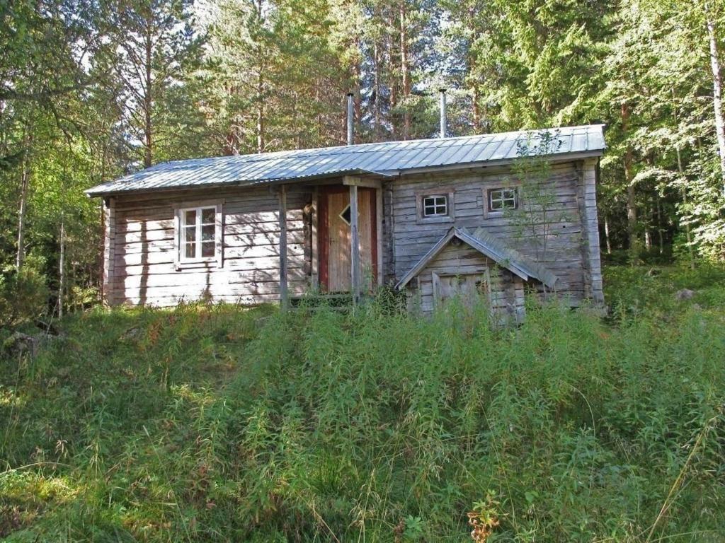 una pequeña casa de madera en medio de un campo en Einfache Holzhütte für das wahre Naturerlebnis am Stausee, en Ytterhogdal
