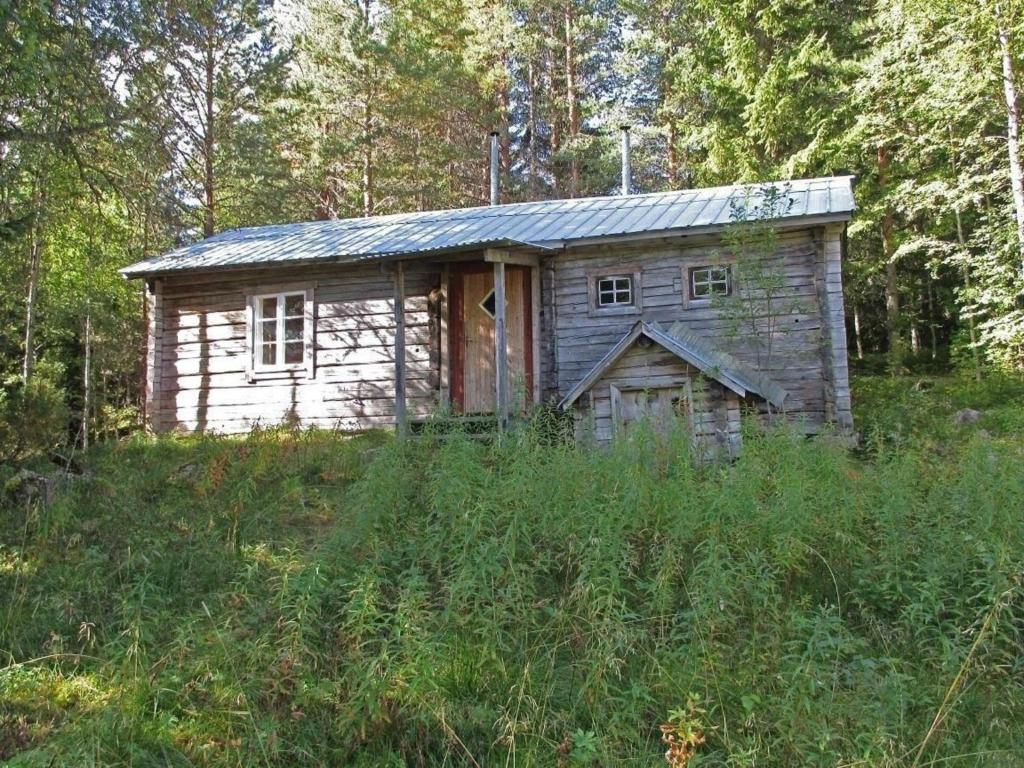 uma pequena casa de madeira no meio de um campo em Einfache Holzhütte für das wahre Naturerlebnis am Stausee em Ytterhogdal