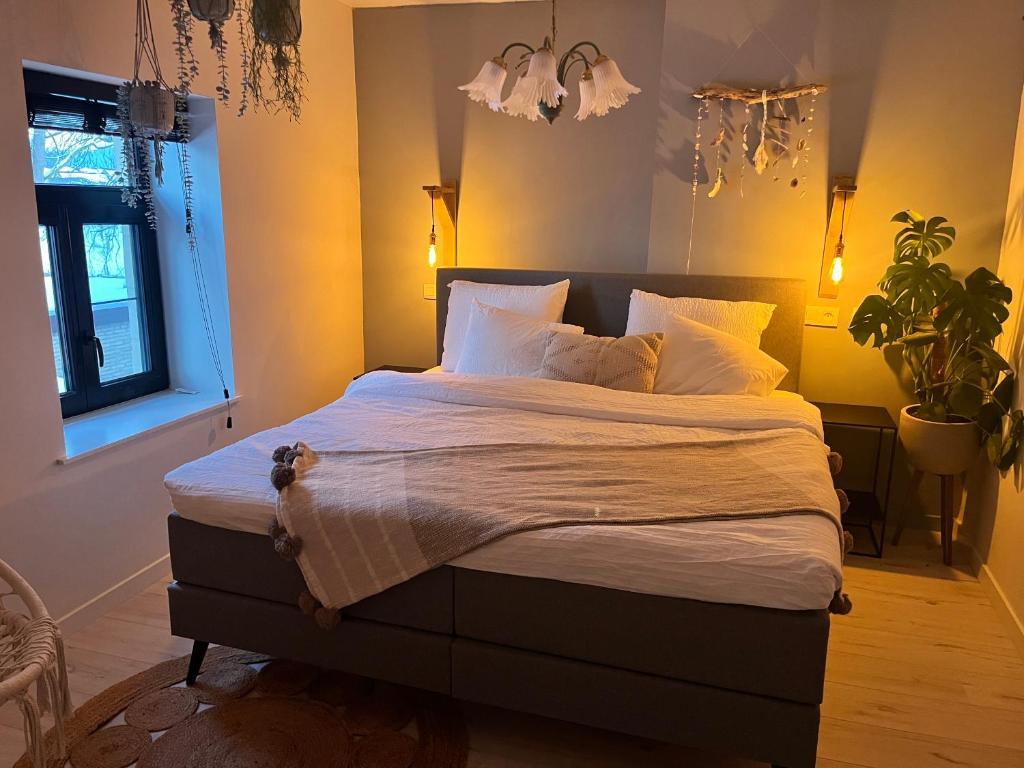 ein Schlafzimmer mit einem großen Bett mit weißer Bettwäsche und Kissen in der Unterkunft De Koer Kanne in Kanne