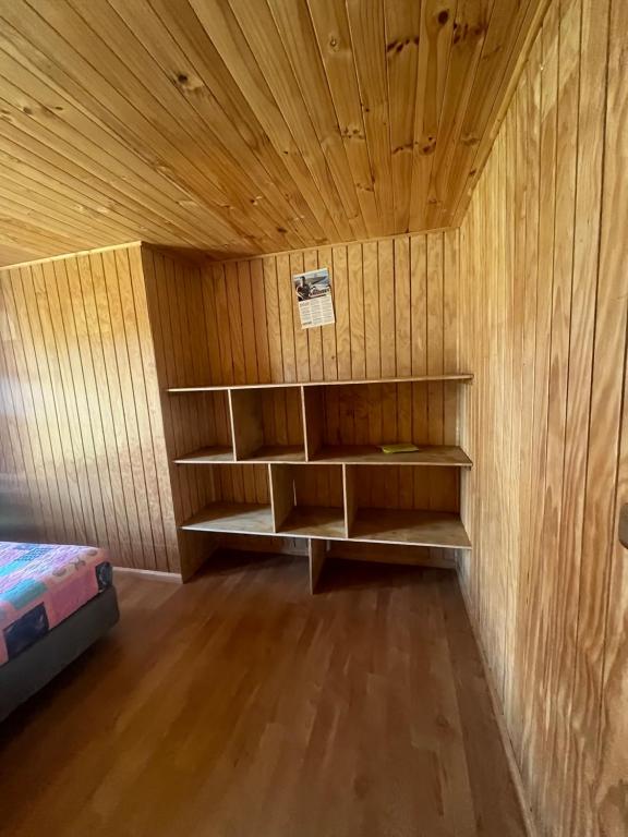 Zimmer mit Holzwänden und Regalen in einem Zimmer in der Unterkunft Los Dudys in Castro