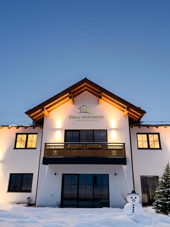 a building with a snowman in front of it at Höra‘s Apartments Hammerbergblick in Münchberg