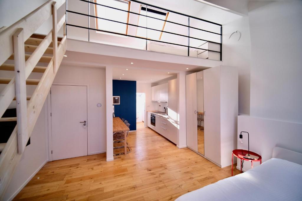 a bedroom with a bed and a staircase in a room at Smart Appart - City Center in Brussels
