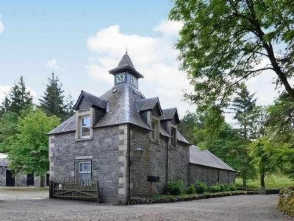 a building with a clock tower on top of it at Charmantes Ferienhaus in Tweedsmuir mit Grill und Garten in Polmood