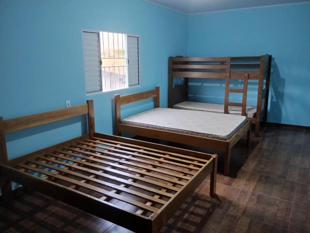 two bunk beds in a room with a blue wall at Chácara Rodrigues in Piedade