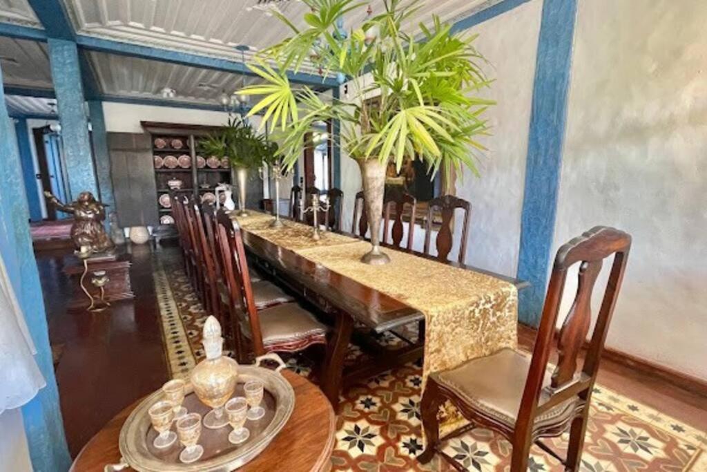 a dining room with a long table and chairs at Historical Mansion in Pampulha in Belo Horizonte