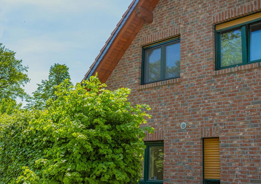 um edifício de tijolos com uma árvore em frente em Firmen-Familien-Villa em Heiligengrabe