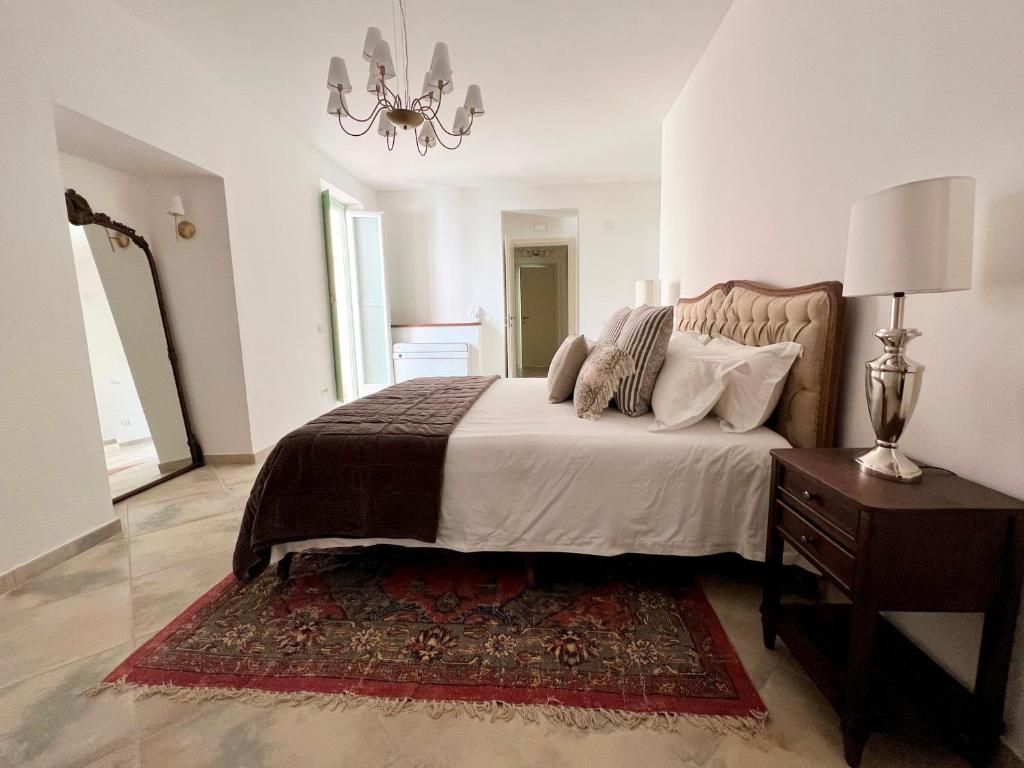 1 dormitorio con 1 cama y 1 mesa con lámpara en Palazzo Maratea a luxurious 1 bedroomed apartment in a 500 year old Palazzo, en Campagna