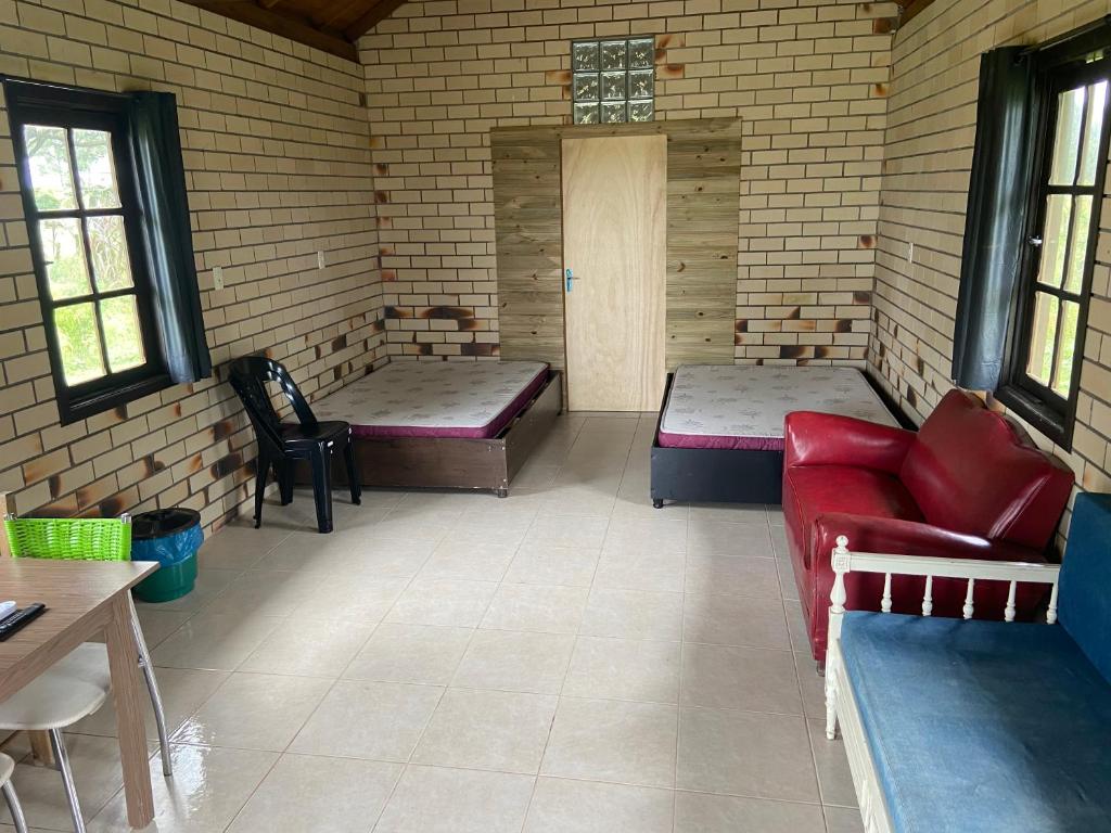 ein Zimmer mit 2 Betten und einem Sofa darin in der Unterkunft Cabana de Campo, Praia e Piscina em Torres, Não fornecemos lençóis, No proporcionamos sábanas in Torres