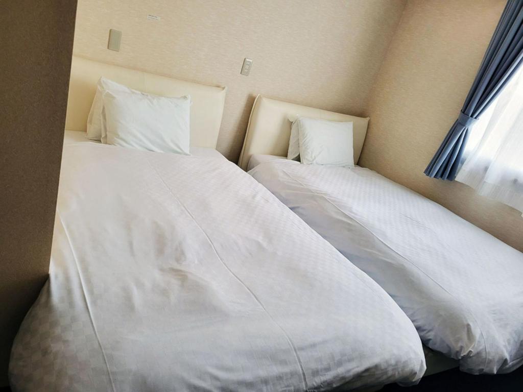 En eller flere senger på et rom på Okasan Hotel - Vacation STAY 60562v