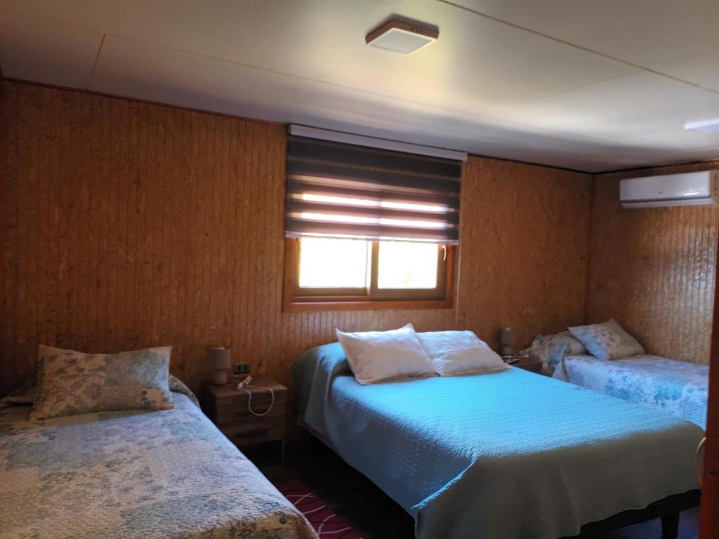 1 Schlafzimmer mit 2 Betten und einem Fenster in der Unterkunft Casa Chiloe in Rauco