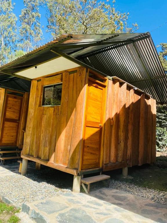 a wooden building with a roof on top of it at LA HACIENDA LODGE in Santa Teresa