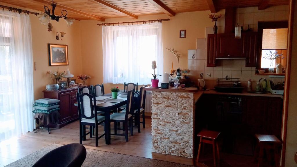 une cuisine avec une table et des chaises et une cuisine avec un comptoir dans l'établissement Enklawa Spokoju, 