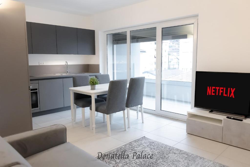 a kitchen and dining room with a table and a tv at Elegant Apartments in Lugano in Lugano