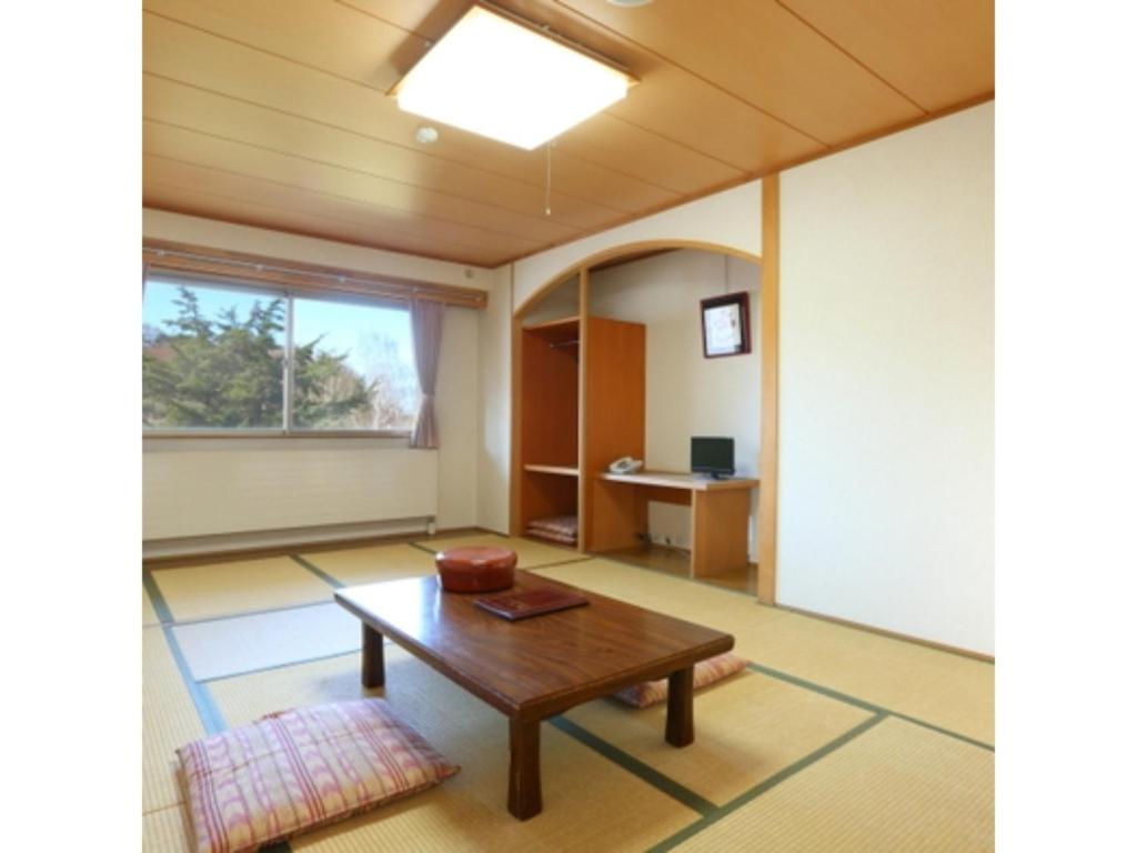 un soggiorno con tavolo e finestra di Hotel Mount Shiga - Vacation STAY 95300v a Yamanouchi