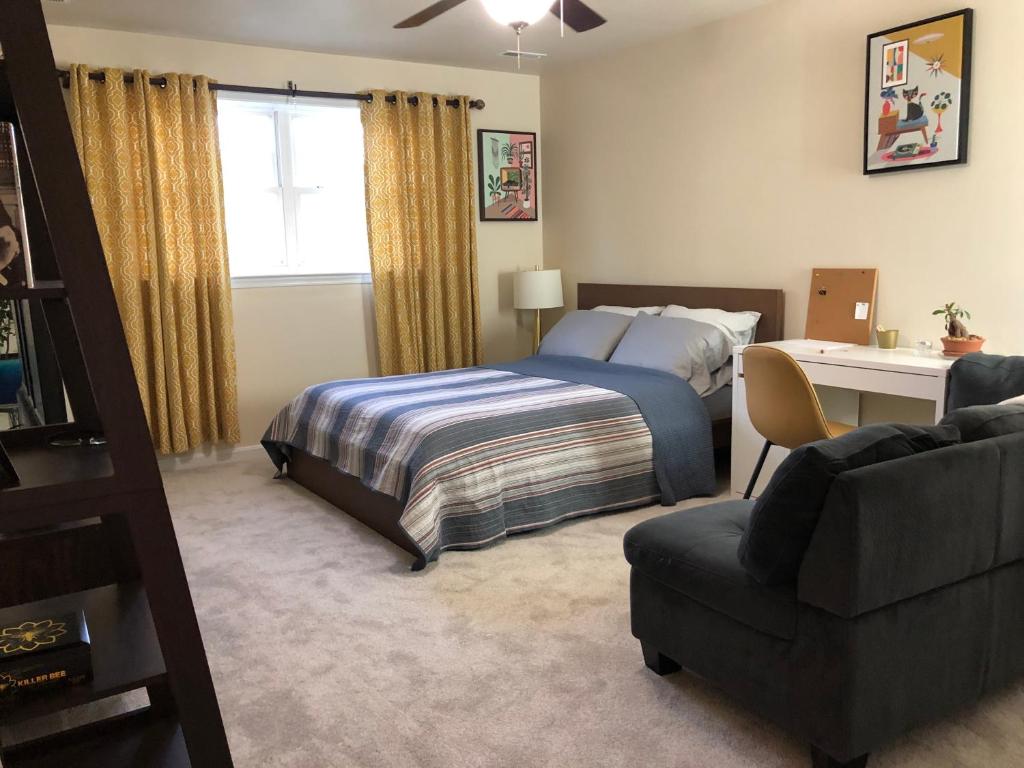 een slaapkamer met een bed, een bureau en een bank bij Mansfield St in Fredericksburg