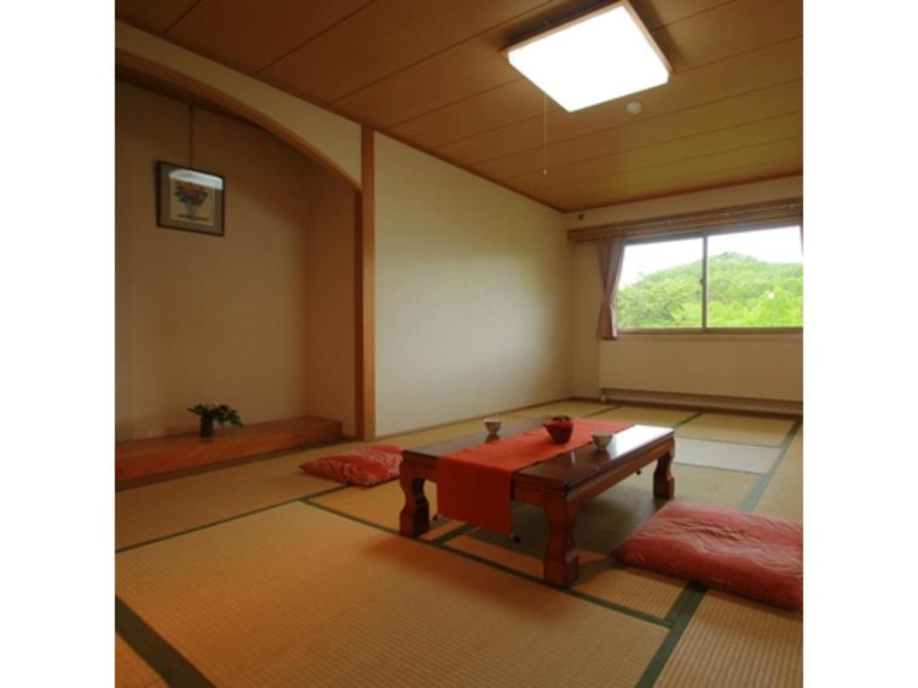 ein leeres Zimmer mit einem Tisch und einem Fenster in der Unterkunft Hotel Mount Shiga - Vacation STAY 95224v in Yamanouchi