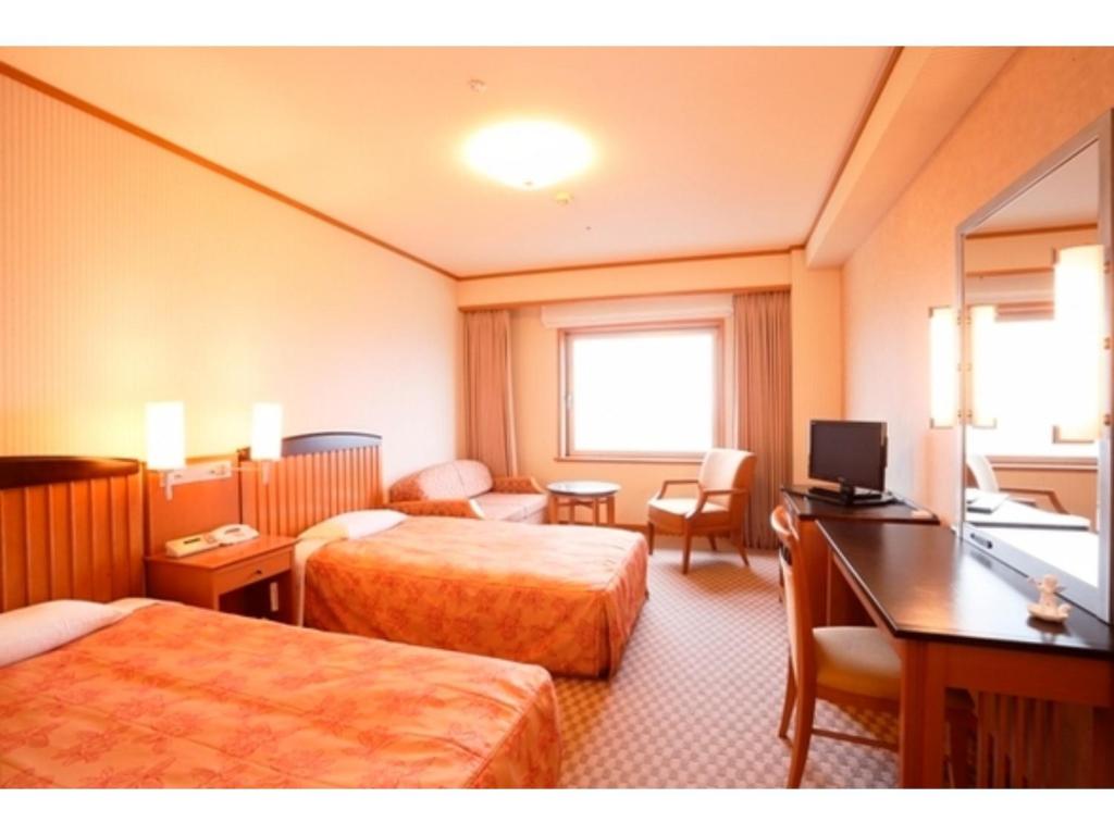Aeria Tohno - Vacation STAY 62233v في Tōno: غرفة فندقية بسريرين ومكتب