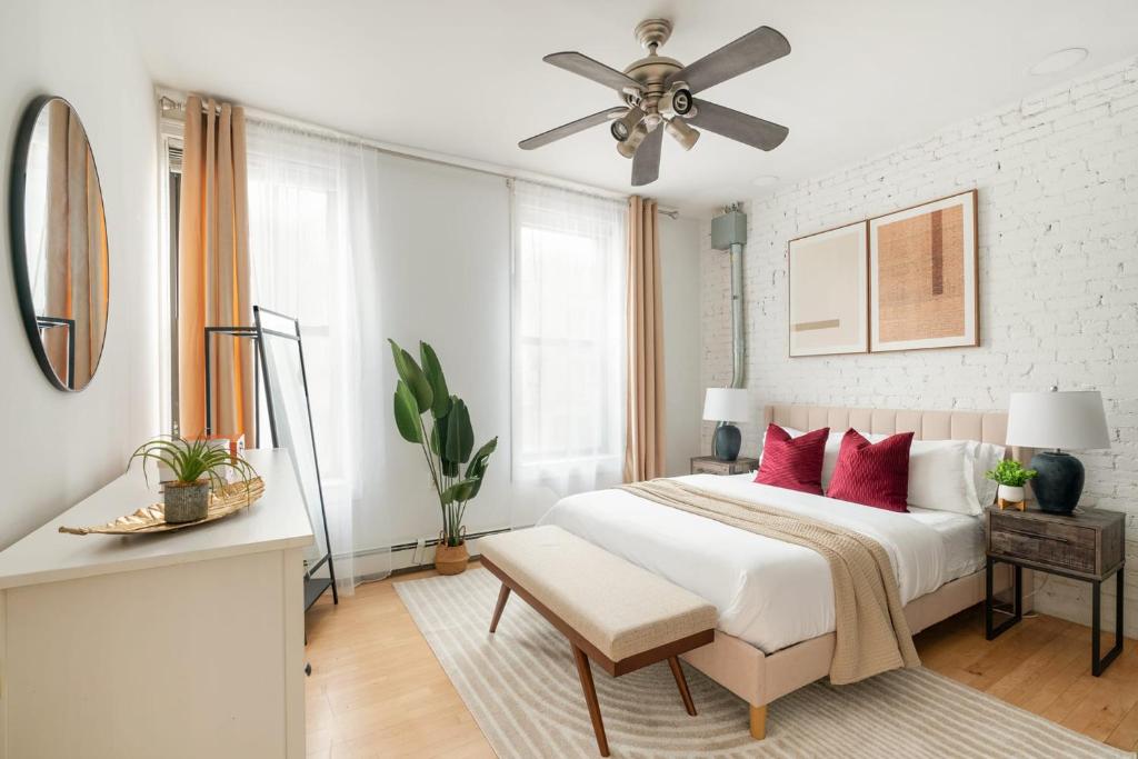 a white bedroom with a bed and a ceiling fan at 139-2W Prime west village Furnished 2BR Best value in New York