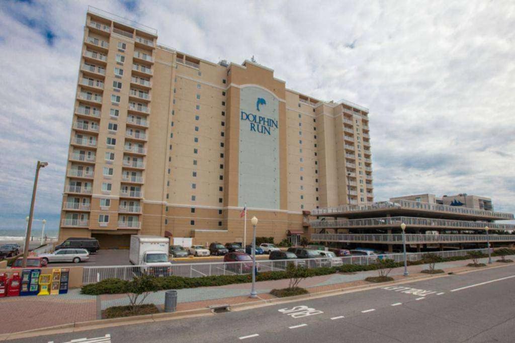 a large building with a parking lot in front of it at Bikinis and Martinis at Dolphin Run-Oceanfront-Pool! in Virginia Beach