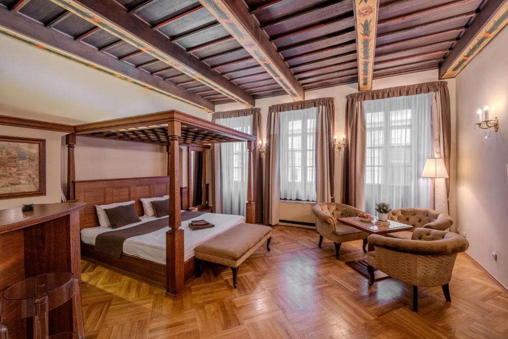 a bedroom with a canopy bed and a table at Traditional Prague Apartment in Prague