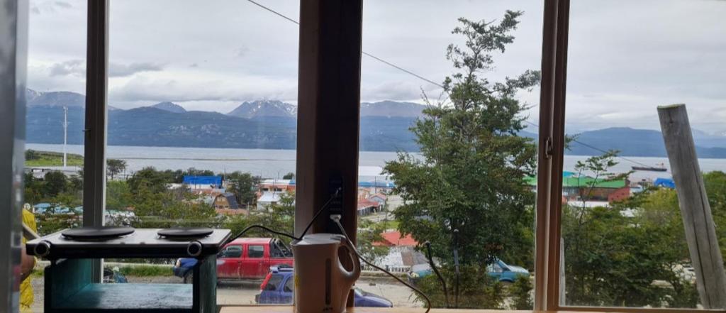 a window with a view of the water and mountains at Cabaña Puerto Williams in Puerto Williams