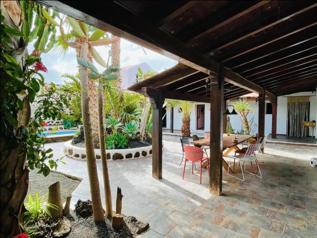 a patio with a wooden pergola and a table and chairs at Casa Cocolores in Villaverde