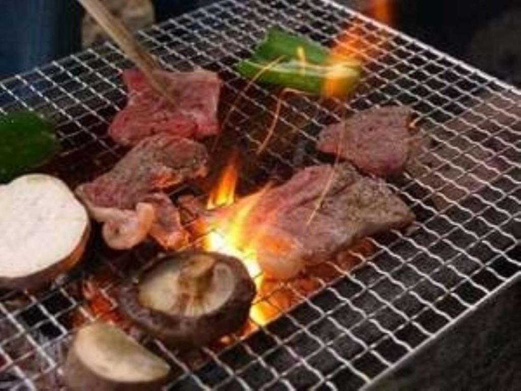 un gril avec de la viande et d'autres aliments dessus dans l'établissement Lilac Hotels and Resorts - Vacation STAY 53247v, à Kanoya