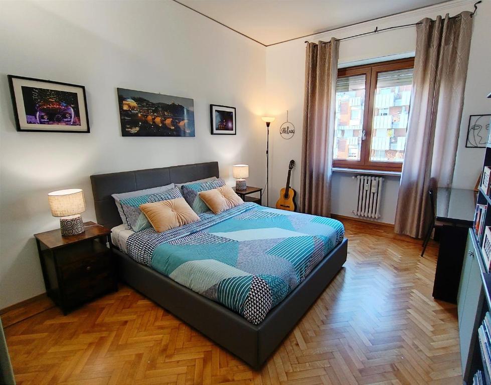 1 dormitorio con 1 cama con edredón azul en Appartamento a 20 minuti dal Centro, Zona Residenziale Tranquilla, Free Parking, 2 Camere, 5 posti letto en Turín