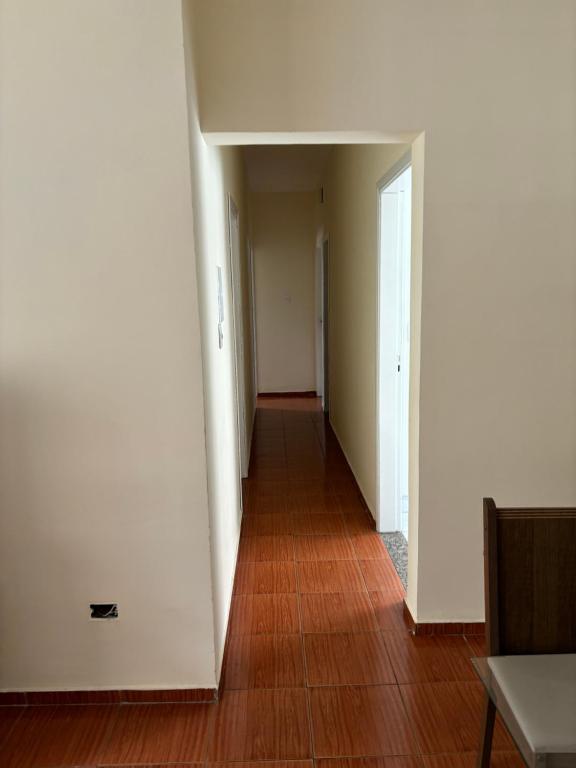 um corredor vazio com paredes brancas e piso de madeira em Hostel do Mineiro em São José dos Campos