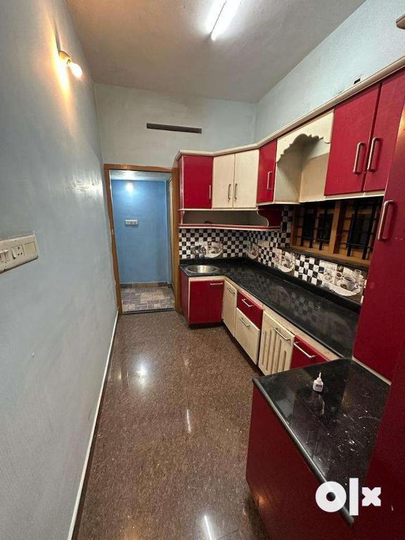 a kitchen with red cabinets and black counter tops at Edans home stay 