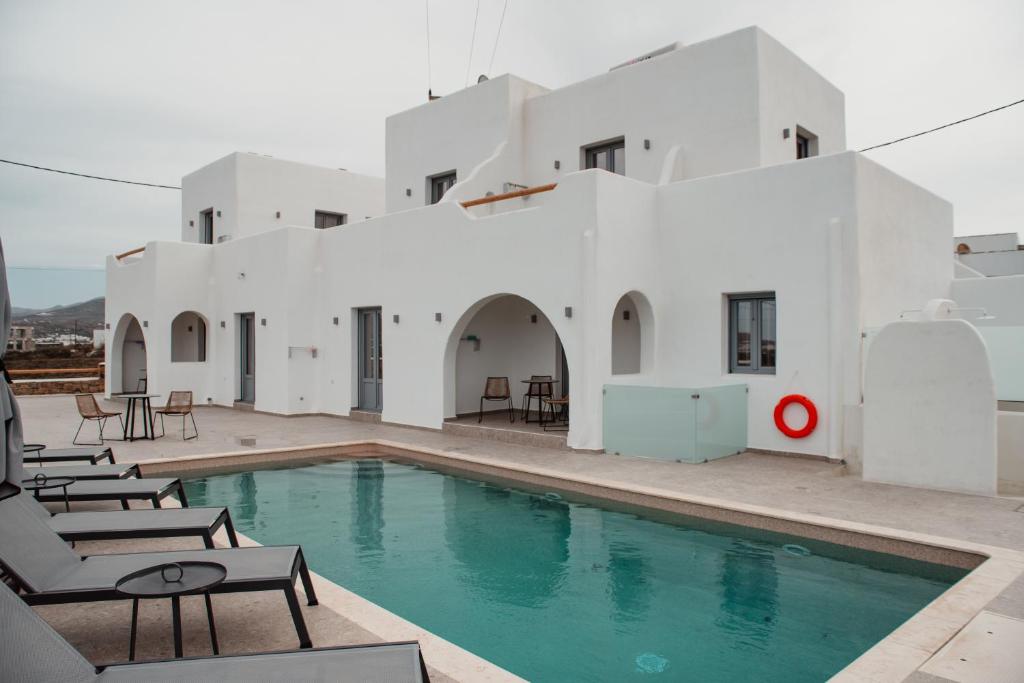 a swimming pool in front of a white building at Anais Of Naxos in Agia Anna Naxos