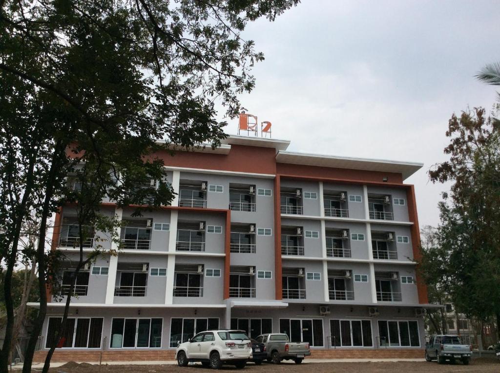 un bâtiment avec des voitures garées devant lui dans l'établissement R2 Apartment Service, à Nakhon Ratchasima