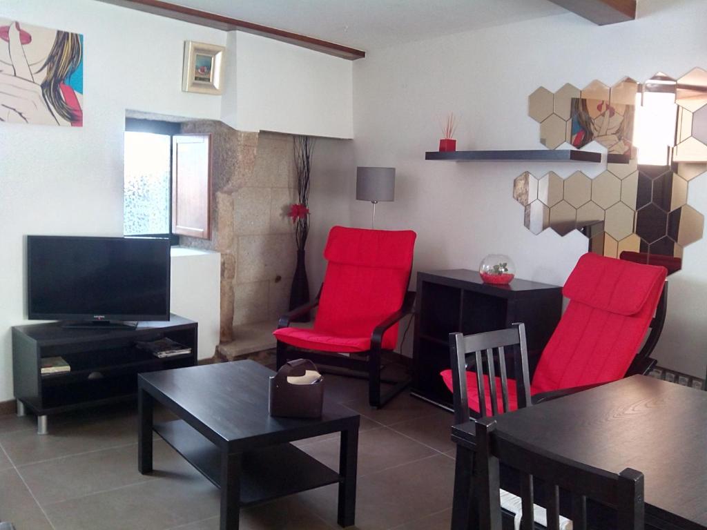 a living room with red chairs and a table at Apartment Hortas in Santiago de Compostela