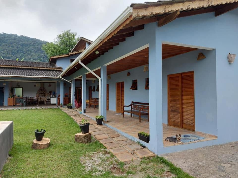 a white house with a patio and a yard at Hospedaria Morada das Orquídeas in São Sebastião