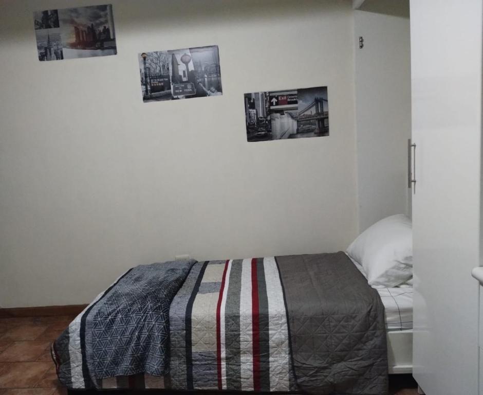 Habitación - Estudio في San Lucas Sacatepéquez: غرفة نوم بسرير وصور على الحائط