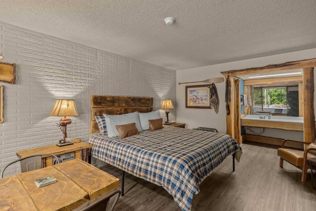 a bedroom with a bed and a bathroom with a tub at Stonegate Lodge - Pool & Firepits Room #208 in Eureka Springs