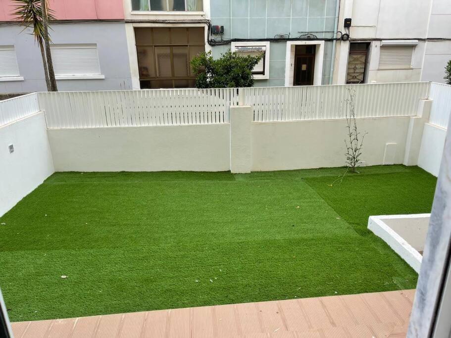 a yard with a white fence and green grass at Lovely 2 bedroom apartment in South Lisbon in Barreiro