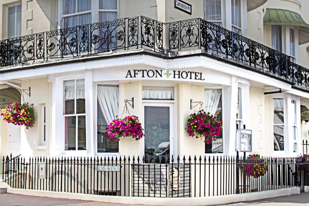 a hotel with a balcony and flowers in front of it at Afton Hotel in Eastbourne