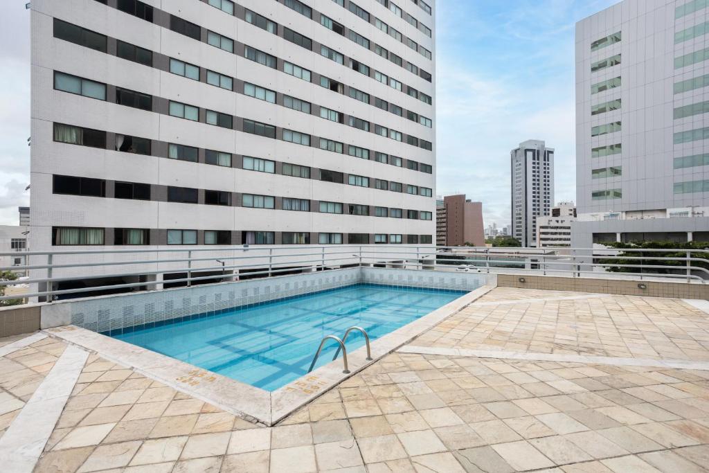 a swimming pool in front of a building at Flat Metropoles Ilha do Leite by Easy Home in Recife