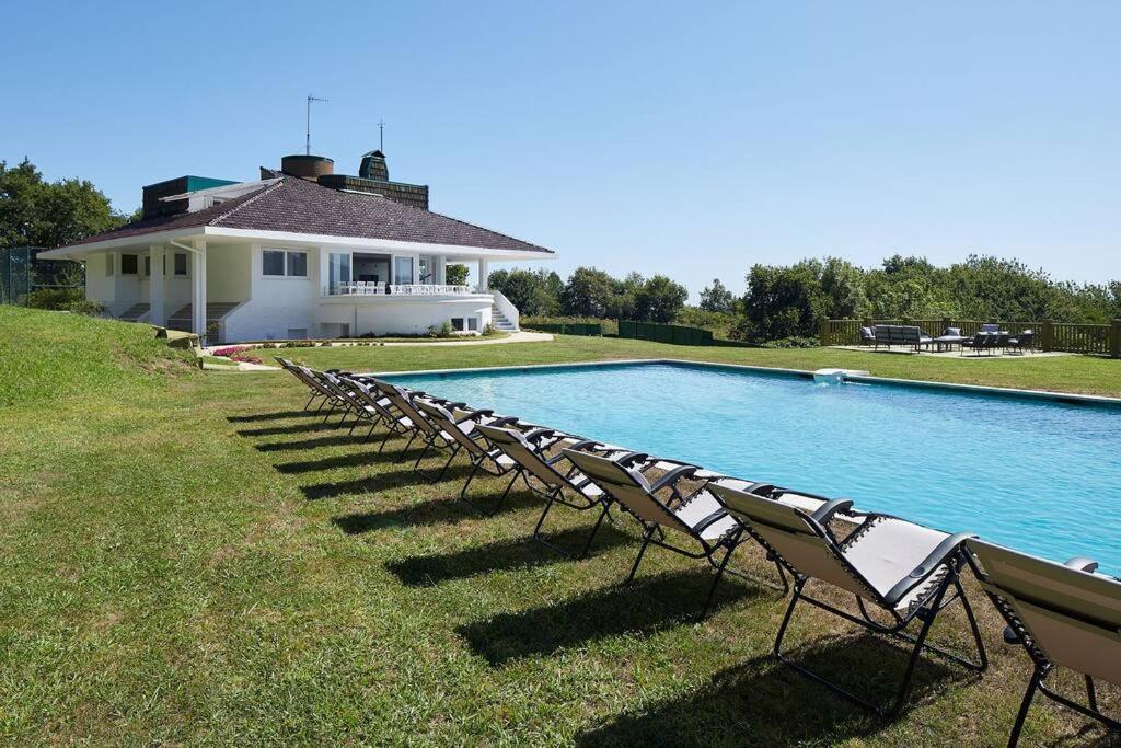 eine Reihe von Stühlen neben einem Pool in der Unterkunft Villa with pool - fantastic view in Hondarribia