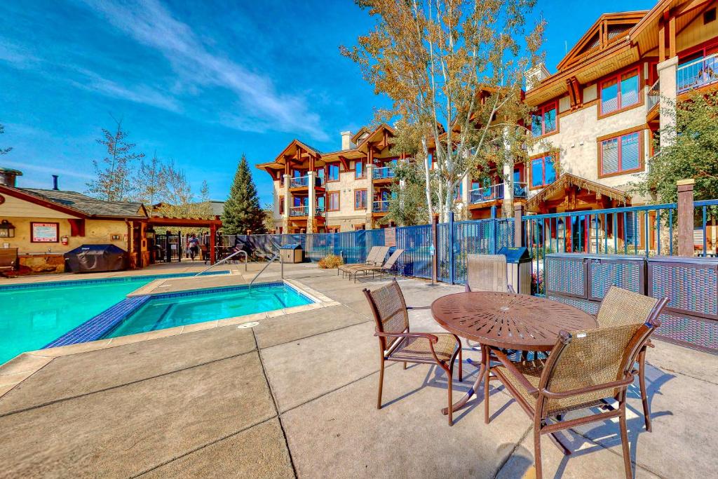 un patio con mesa y sillas junto a una piscina en EagleRidge Lodge and Townhomes, en Steamboat Springs