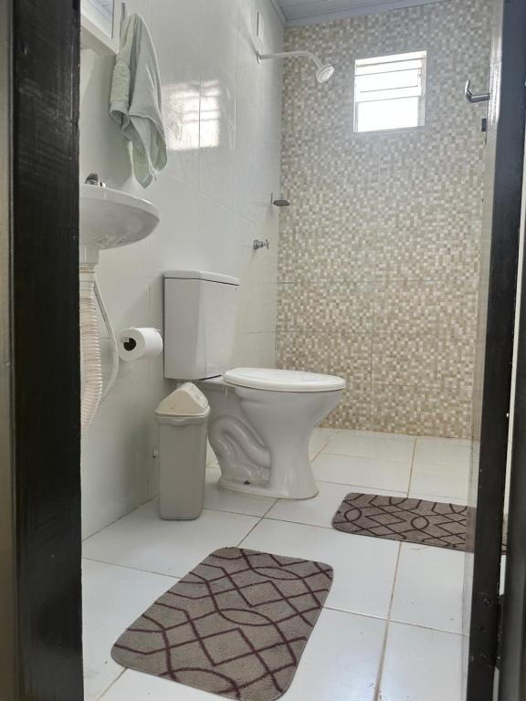 La salle de bains est pourvue de toilettes, d'un lavabo et d'une douche. dans l'établissement Vivendas Piscina e Mar, à Aracaju