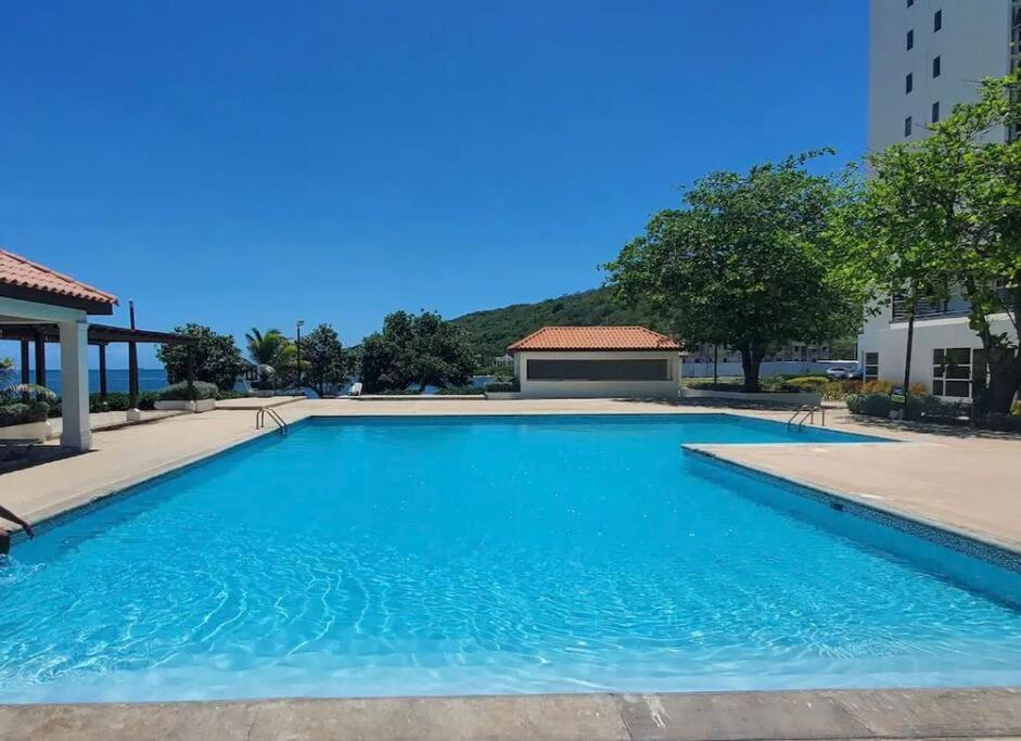 a large swimming pool with blue water at Condo with pool in Portmore in Portmore