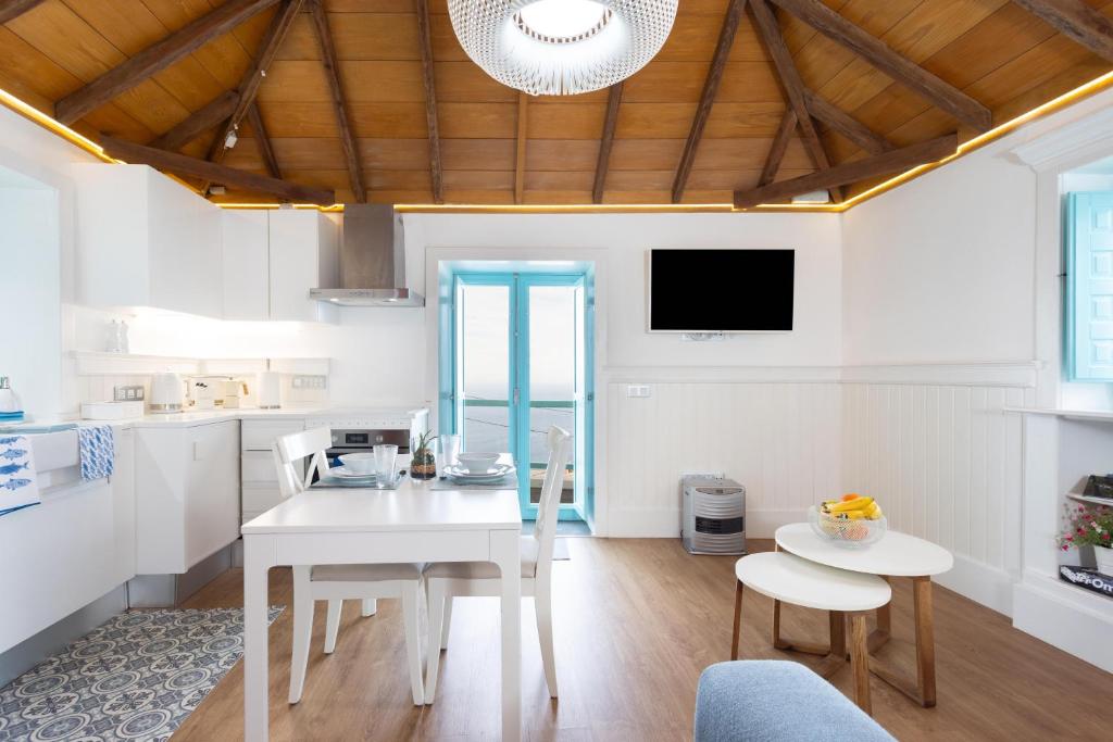 eine Küche und ein Esszimmer mit einem weißen Tisch und Stühlen in der Unterkunft casa mo Tenerife in Las Cruces