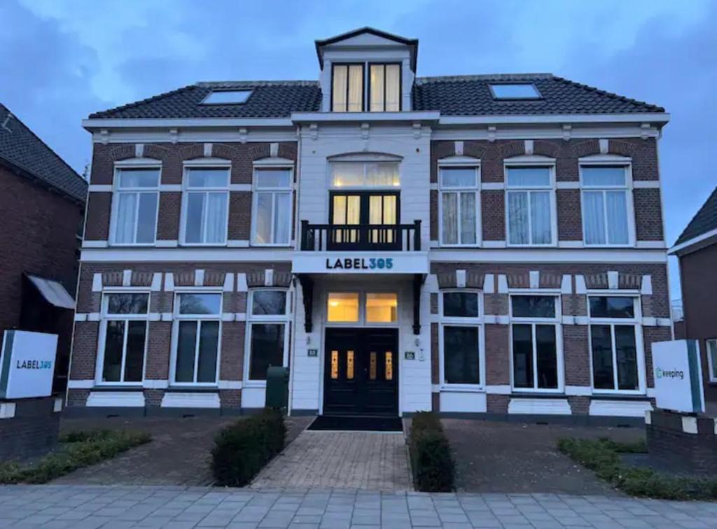 een groot bakstenen gebouw met een bord dat minimaal leest bij City Appartement with Private free parking in Enschede